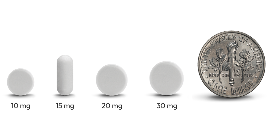 An image of tablets next to a dime for scale.